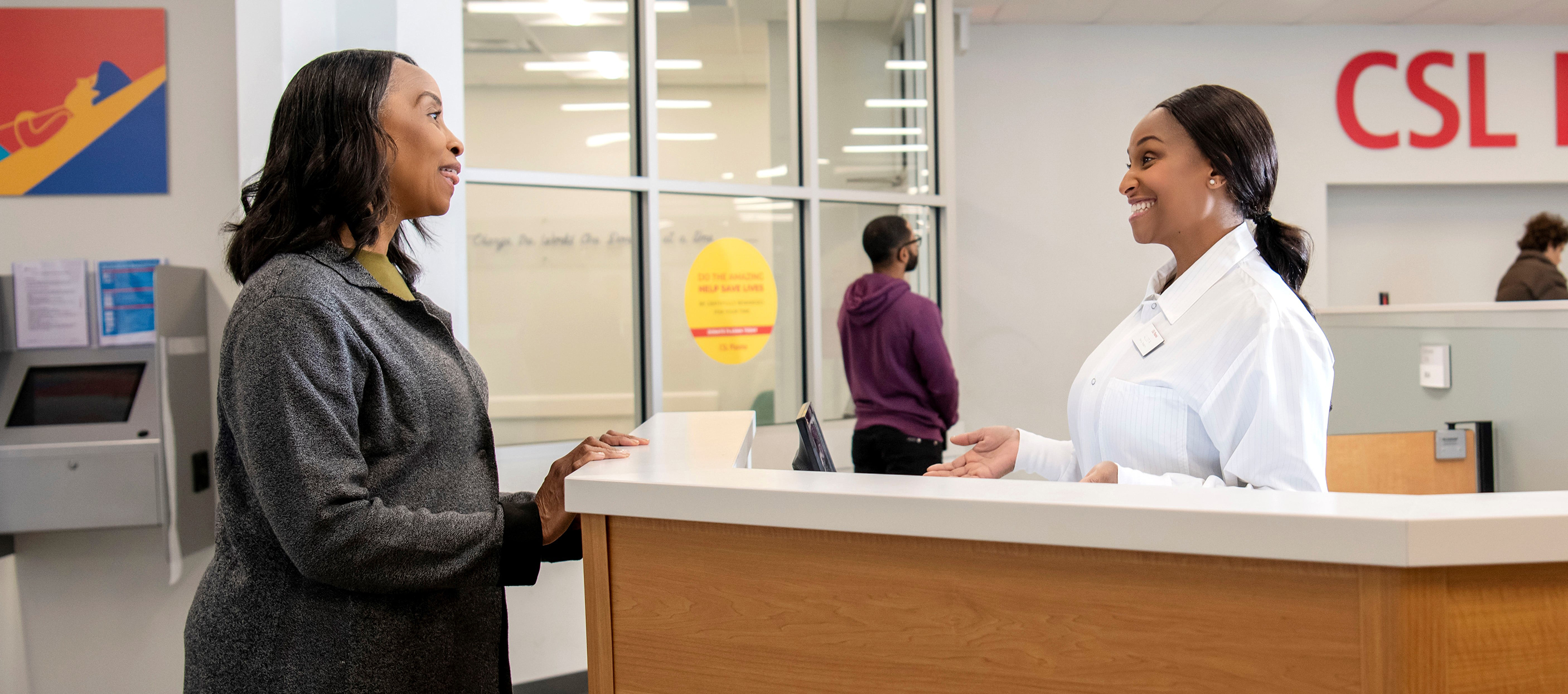 Woman and CSL Plasma specialist speaking at a donation center